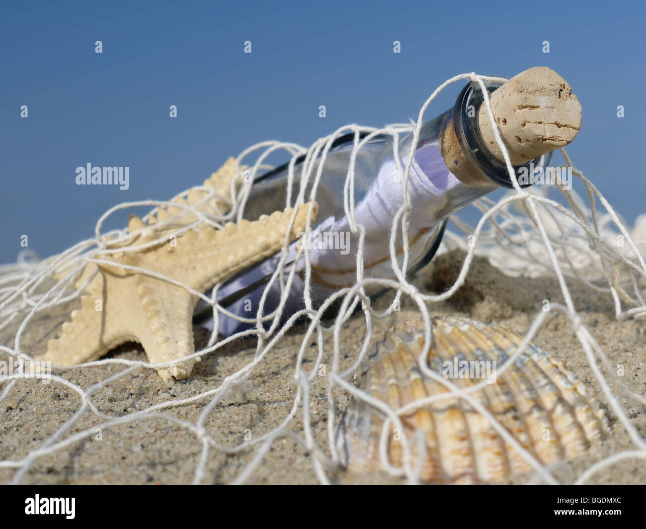 Seestern, Muschel und Flasche mit der Nachricht in das Fischernetz gefangen Stockfoto