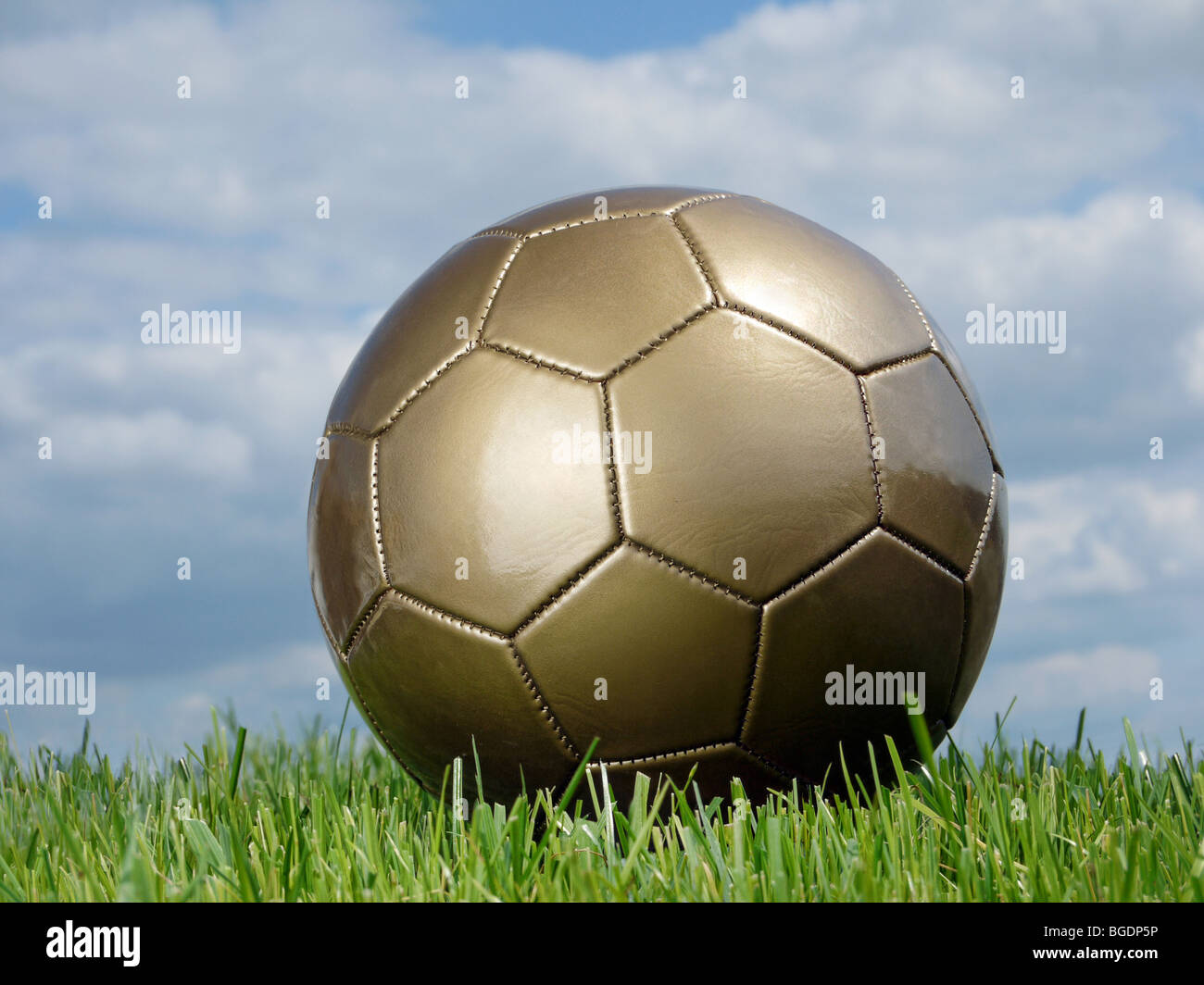 Goldenen Fußball auf dem Rasen gegen den Himmel geschossen Stockfoto