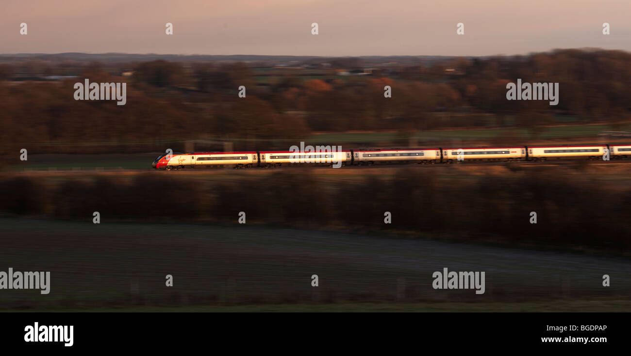 Ein natives Pendolino-Geschwindigkeiten durch Grendon auf der West Coast main Line mit Hintergrund Unschärfe in den Abend. Stockfoto