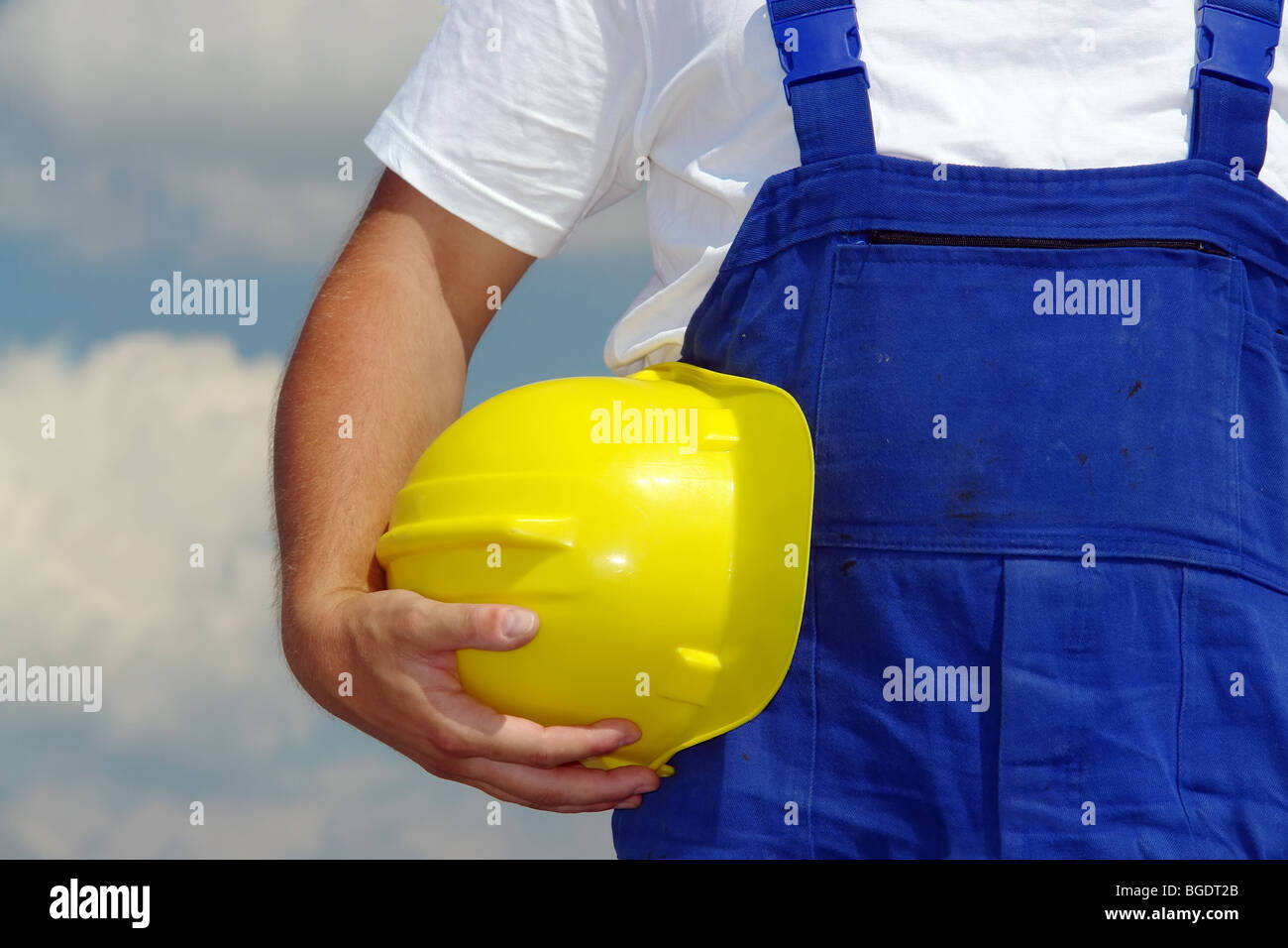 Closeup Aufnahme von Bau Arbeiter Hand mit gelben Helm durch seinen Körper Stockfoto
