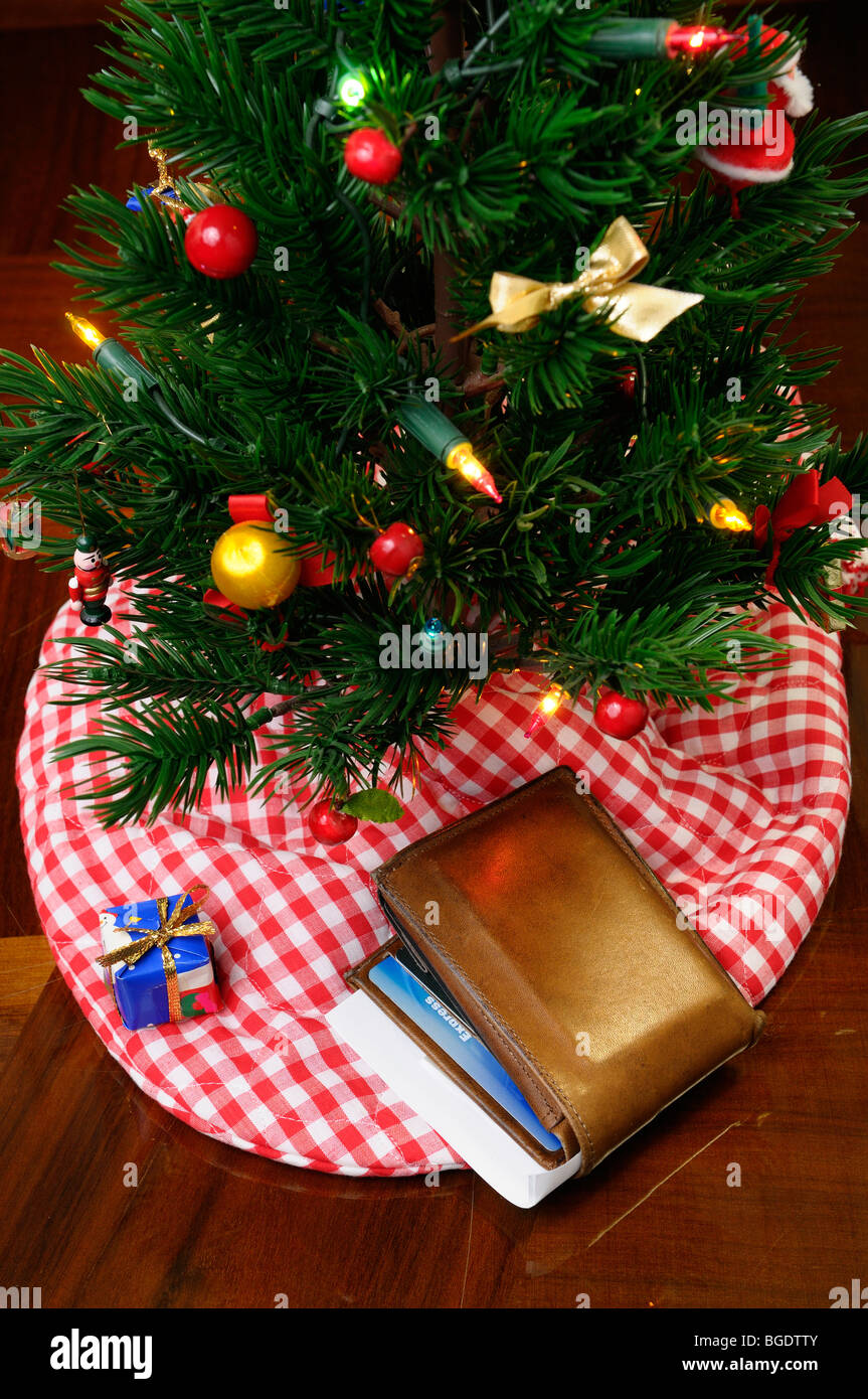 Leder Geldbörse mit Kreditkarten und Scheck unter dem geschmückten Weihnachtsbaum mit einem kleinen Geschenk Stockfoto