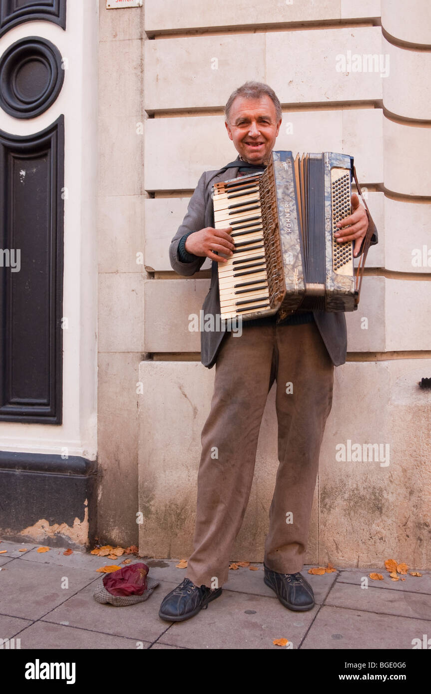 Eine männliche Busker als Straßenmusikant mit einer Ziehharmonika in der Innenstadt in Norwich, Norfolk, Großbritannien Stockfoto