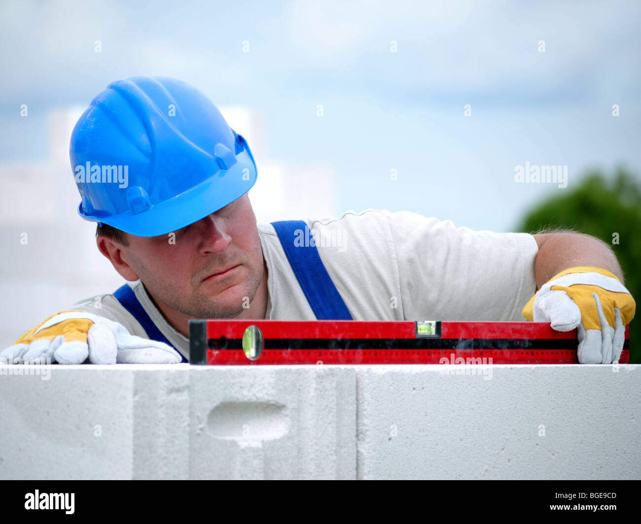 Mason, die Überprüfung der horizontalen Ebene der Hauswand Schicht aus Porenbeton autoklaviert Betonsteine Stockfoto