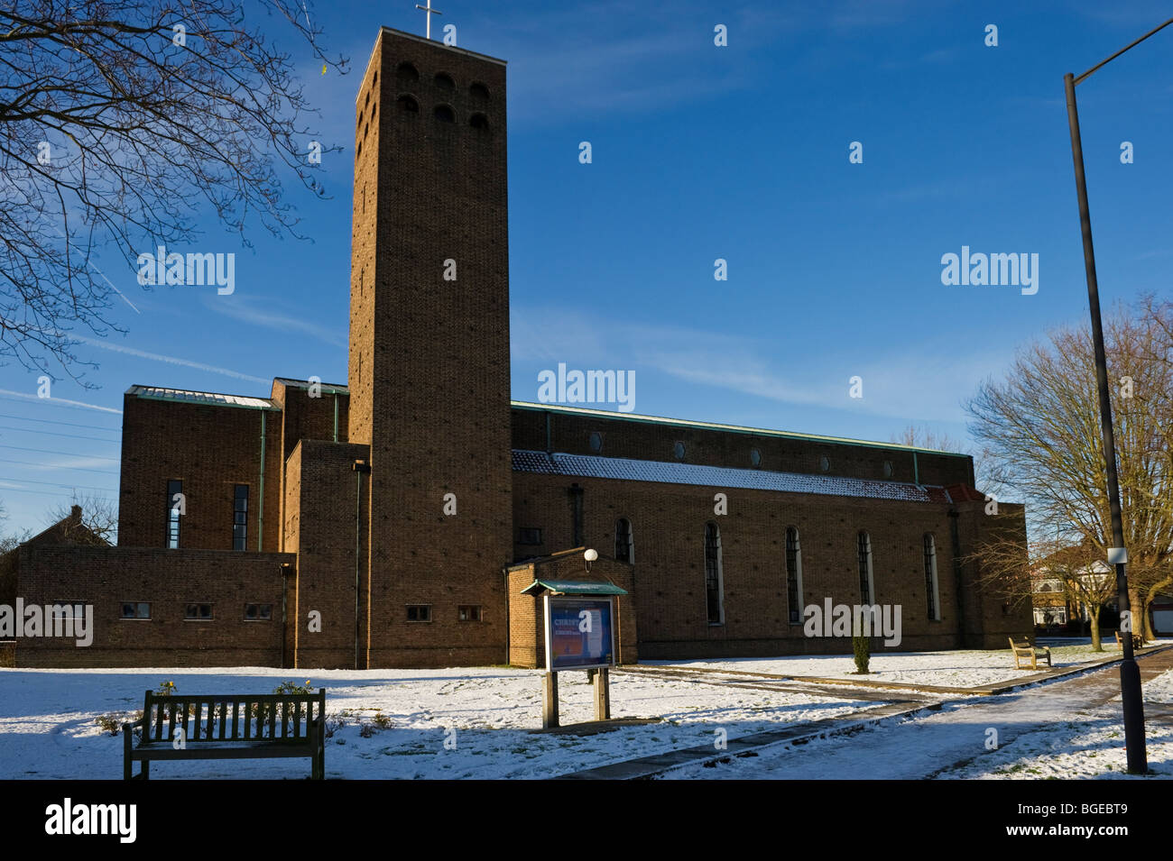 St Alban eine große städtische Pfarrkirche von North Harrow London im Winterschnee und blauem Himmel. Stockfoto