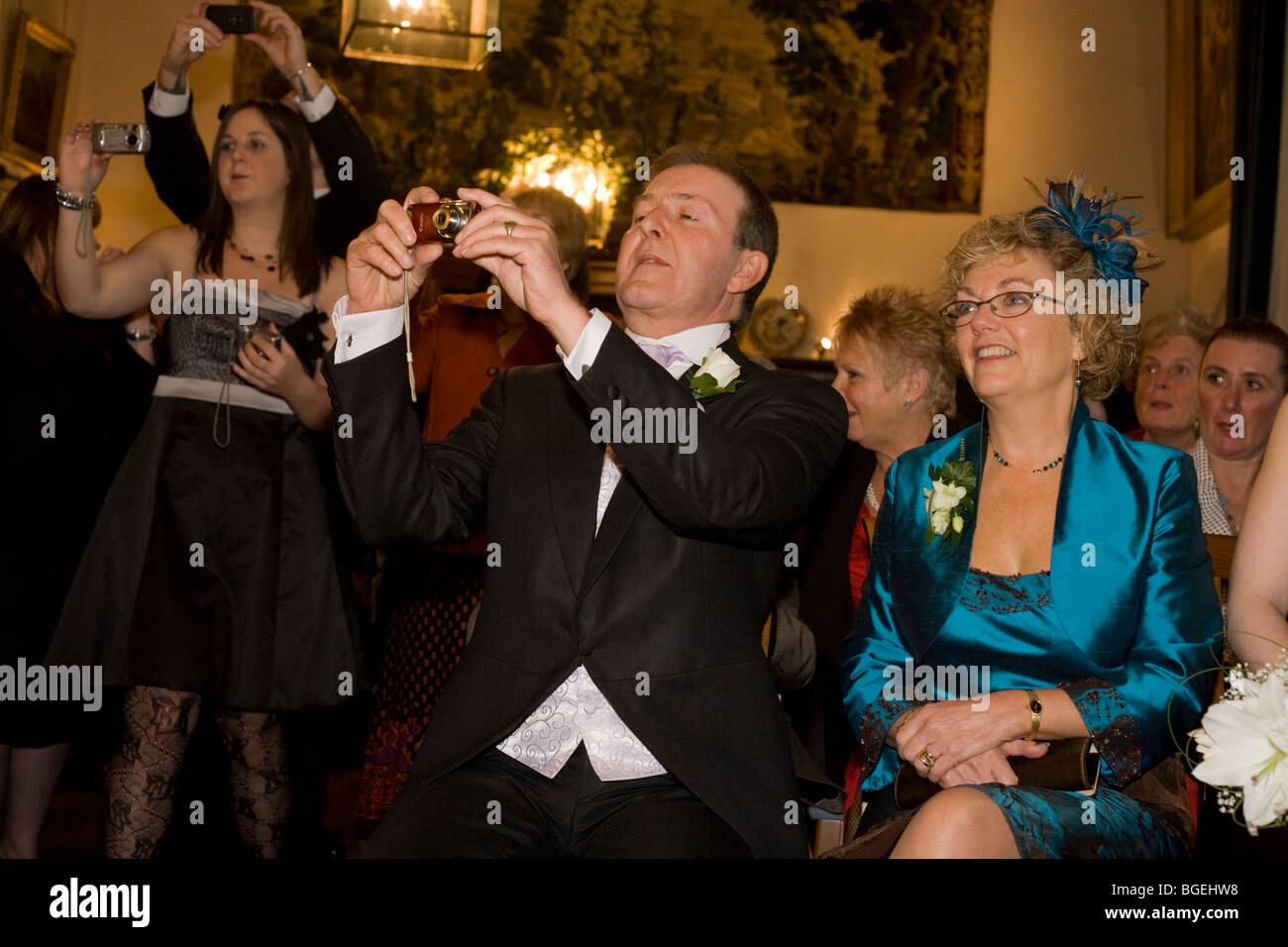 Die Eltern der Braut kümmern sich auf ihre Tochter standesamtliche Trauung bei einer lizenzierten Zeremonie in Essex, England. Stockfoto