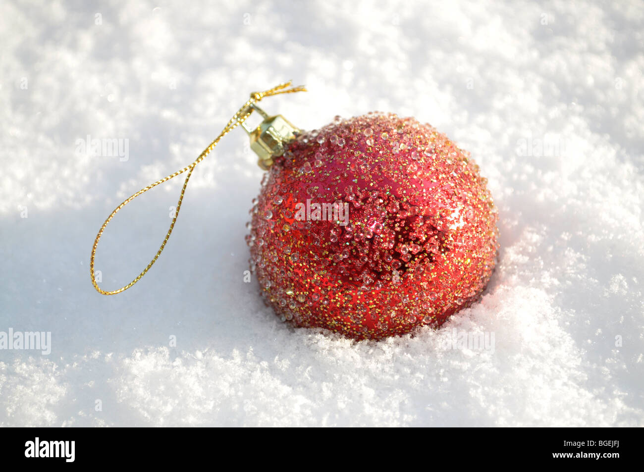 Rote Christbaumkugel im Schnee Stockfoto