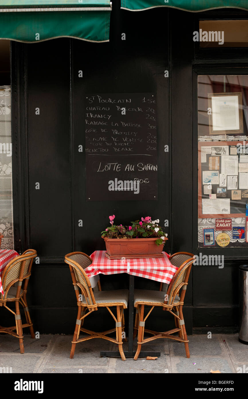 Tische im Freien in einem Paris Café mit aufgegebenen Tischdecken und eine Tafel Menü, Paris, Frankreich Stockfoto