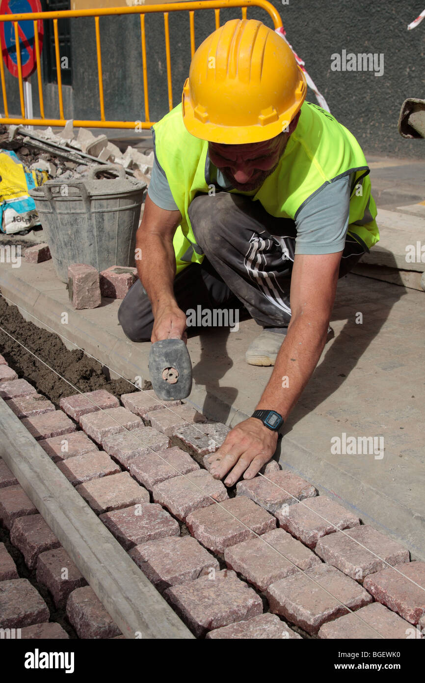 Arbeiter, die Verlegung von Pflastersteinen in der Straße in Puerto De La Cruz-Teneriffa-Kanarische Inseln-Spanien Stockfoto