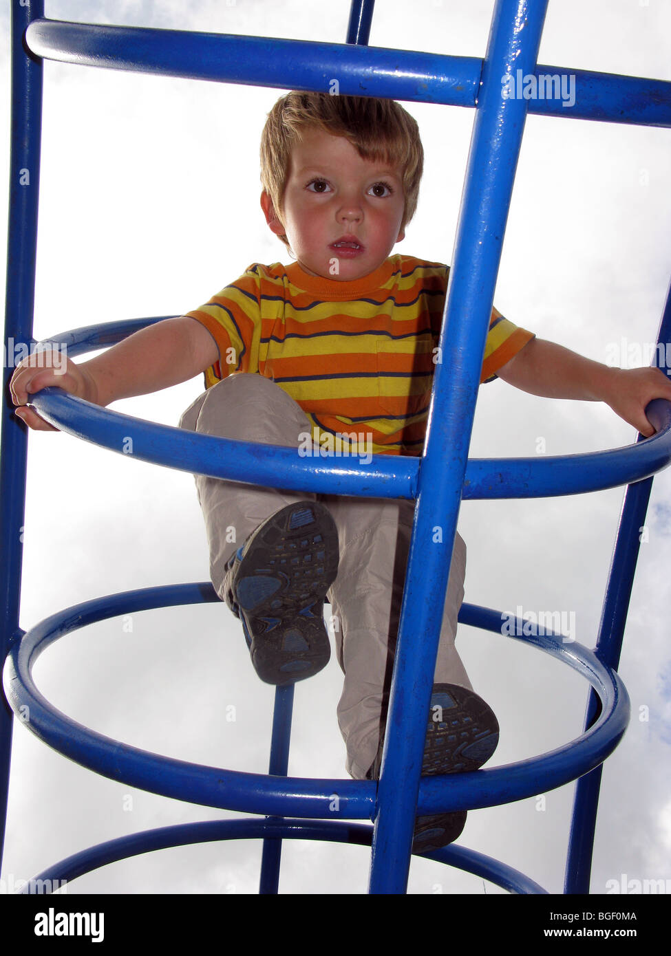 Kind spielt auf einem "Klettergerüst" junge Klettern auf einem Spielplatz Stockfoto