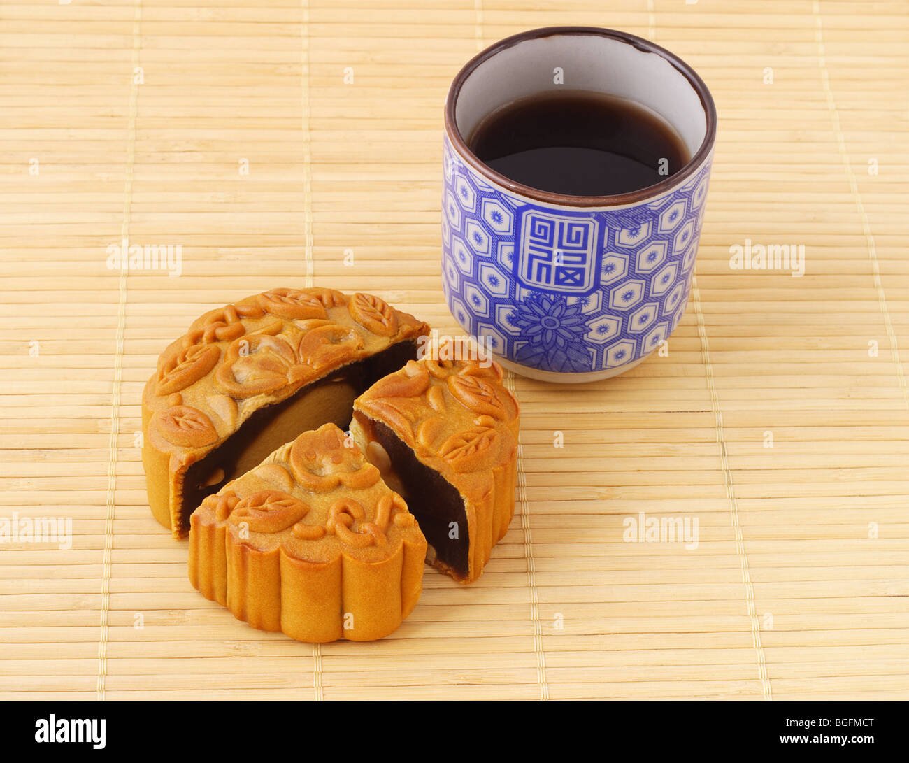 Chinesische Mooncake und Tasse Tee auf Bambusmatte Stockfoto