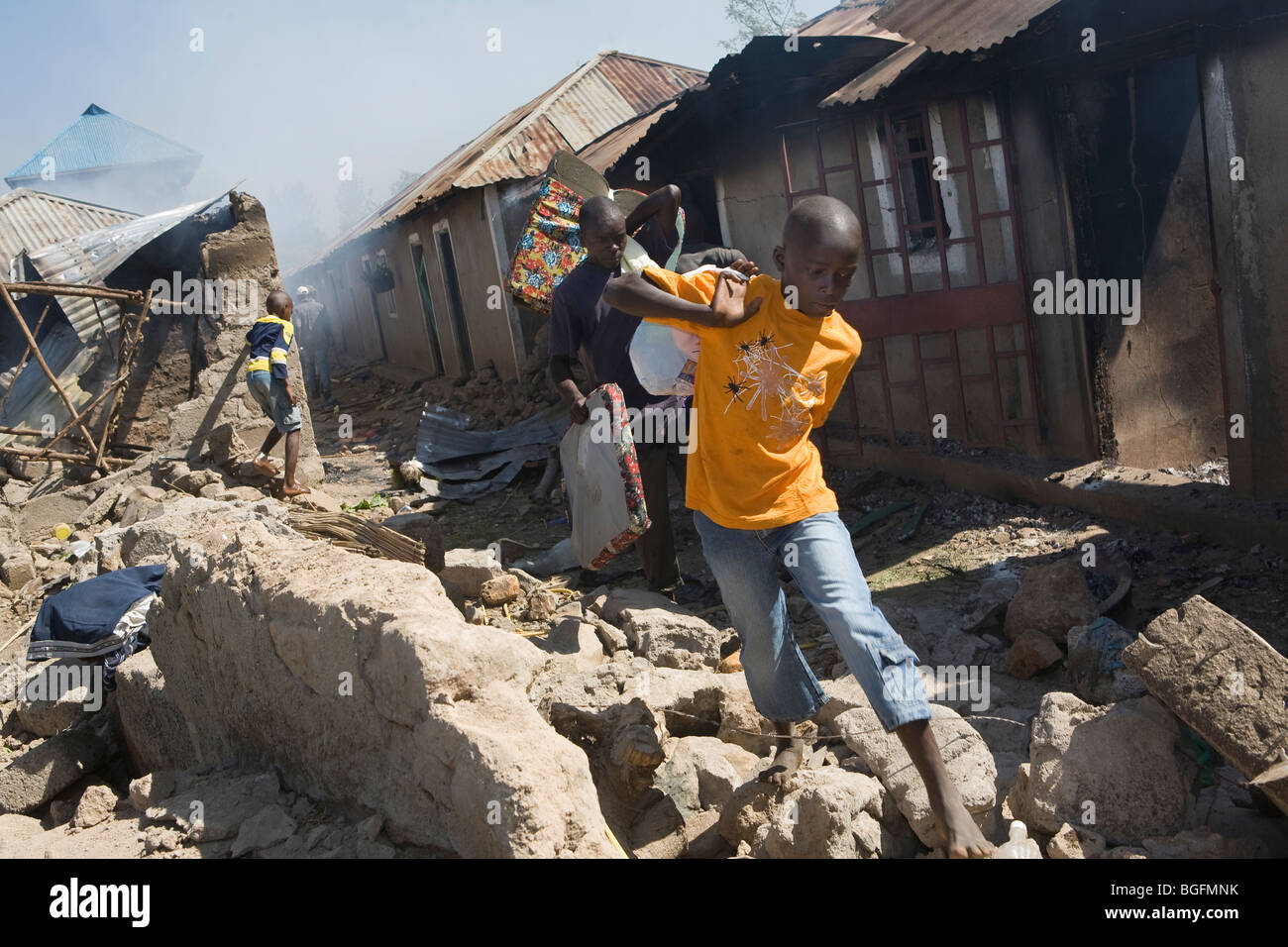 Ein Junge flieht seine brennenden Nachbarschaft in Kenia nach den Wahlen Unruhen, Kisumu, Kenia. Stockfoto