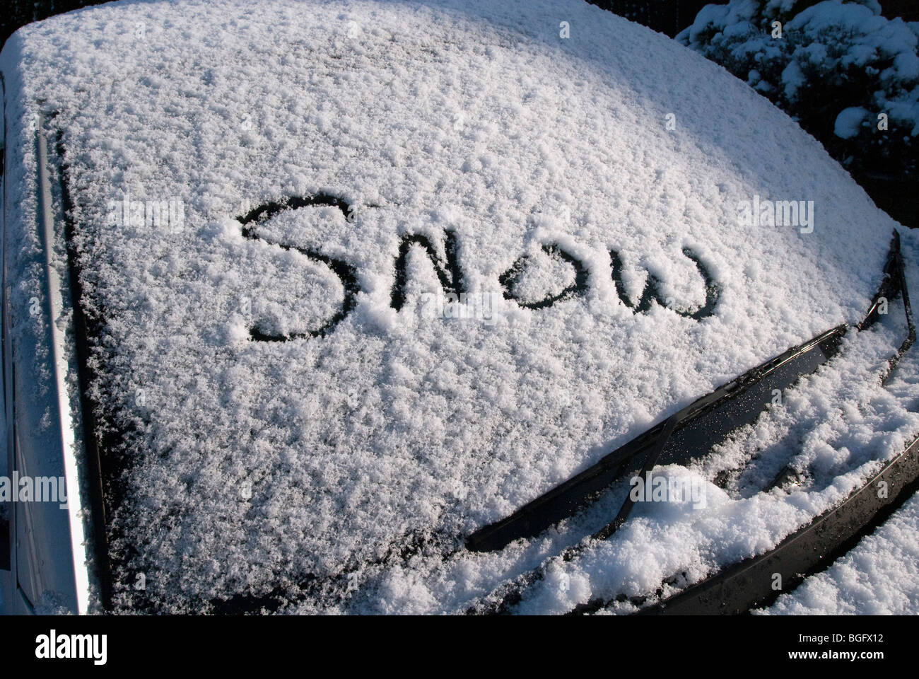 Das Wort Schnee geschrieben im Schnee auf einem Auto Windschutzscheibe Stockfoto