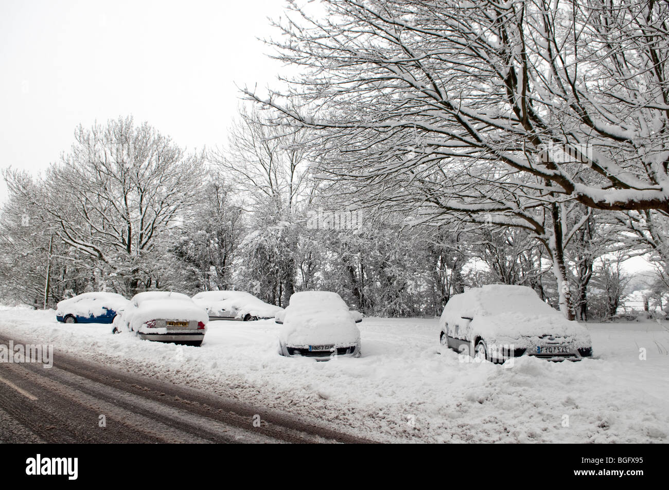 Autos unter Zoll Schnee am Straßenrand begraben. Stockfoto