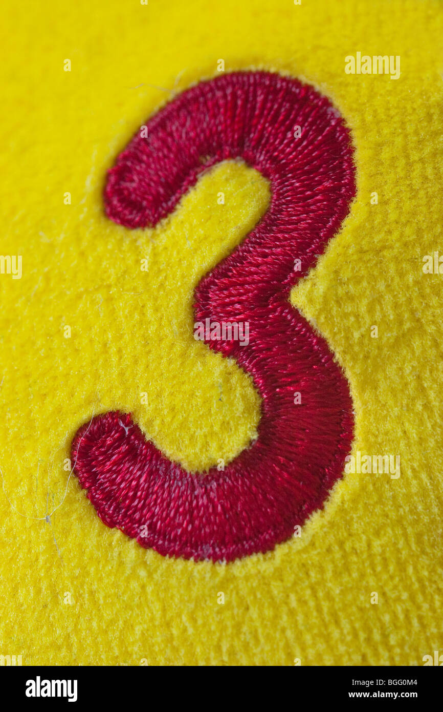 Rote Nummer 3 auf gelben Material genäht Stockfoto