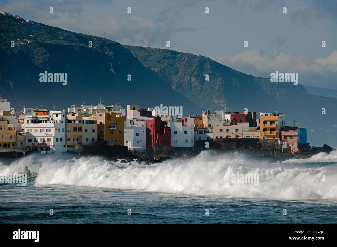 Spanien Teneriffa Kanarische Inseln Puerto De La Cruz Atlantischen Ozean Welle blauen Himmel bunten Gebäuden Höhensonne Stockfoto