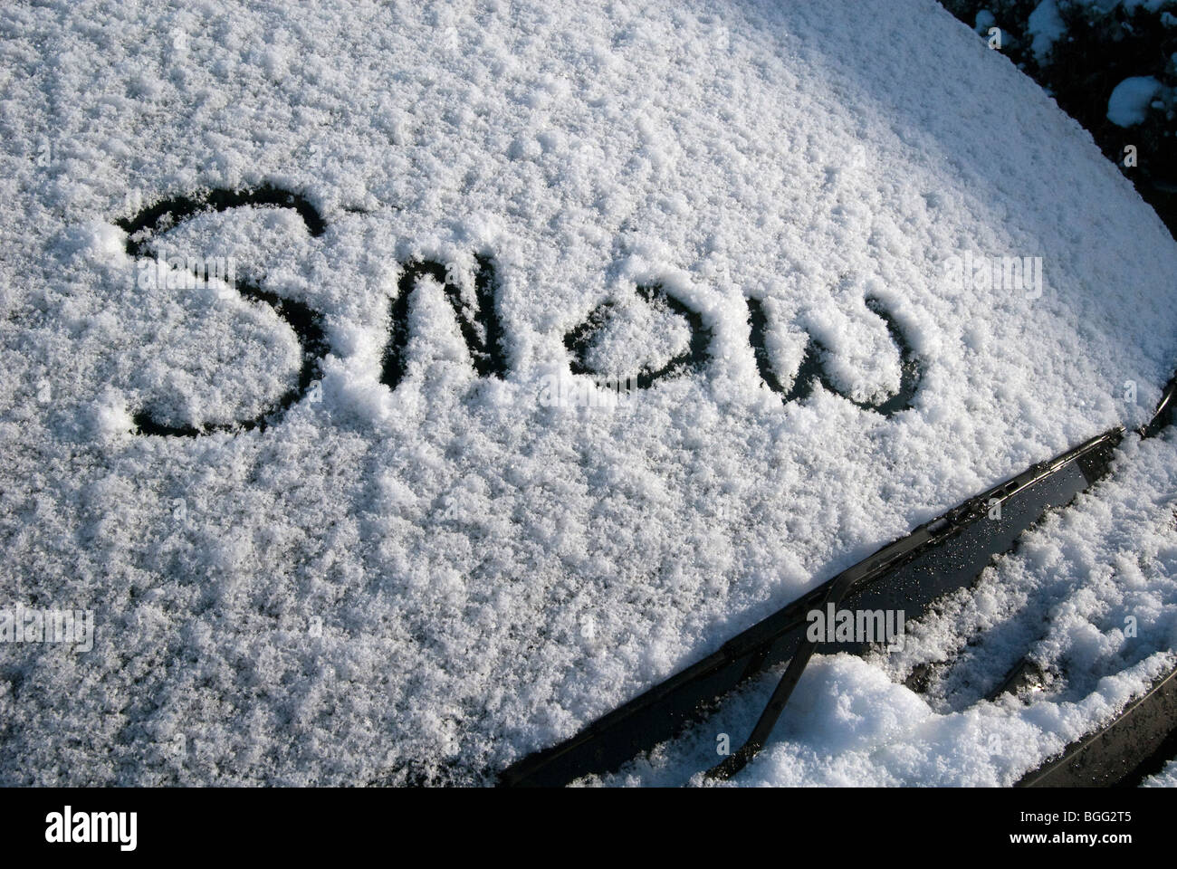 Das Wort Schnee geschrieben im Schnee auf einem Auto Windschutzscheibe Stockfoto