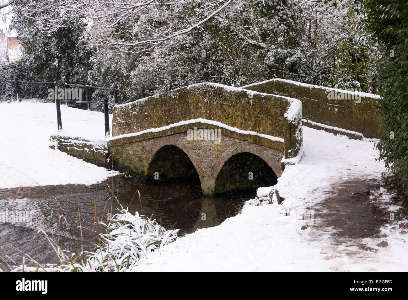Die Pack Horse Bridge und ford in Bide Brook, Lacock im Winterschnee.Wiltshire England Großbritannien Stockfoto