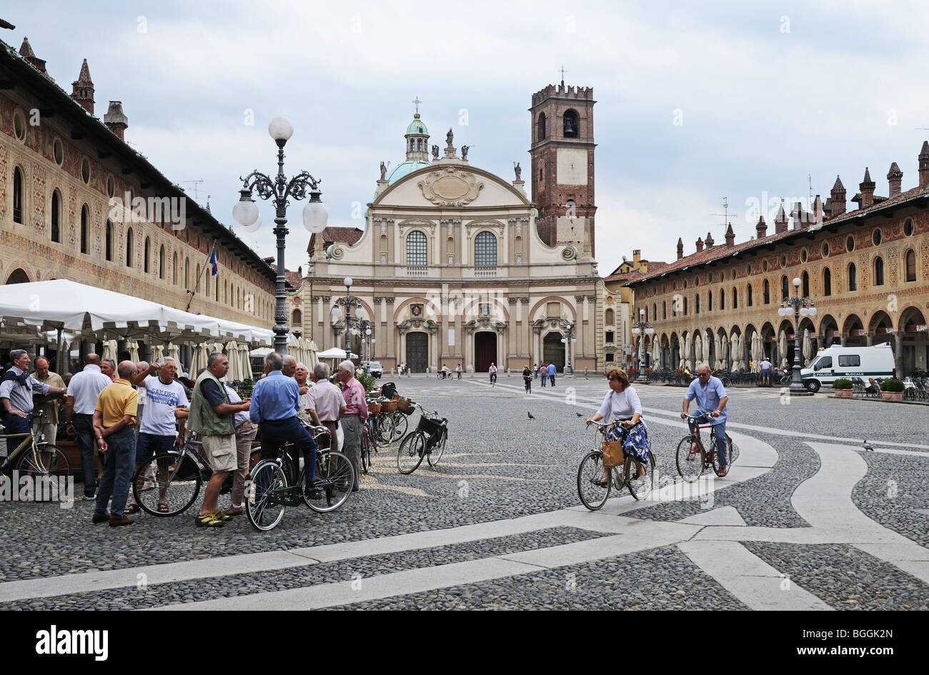 Frauen in Piazza Ducale Vigevano Italien mit 17. Jahrhundert barocke Kathedrale oder Dom entworfen von Antonio da Lonate Radfahren Stockfoto
