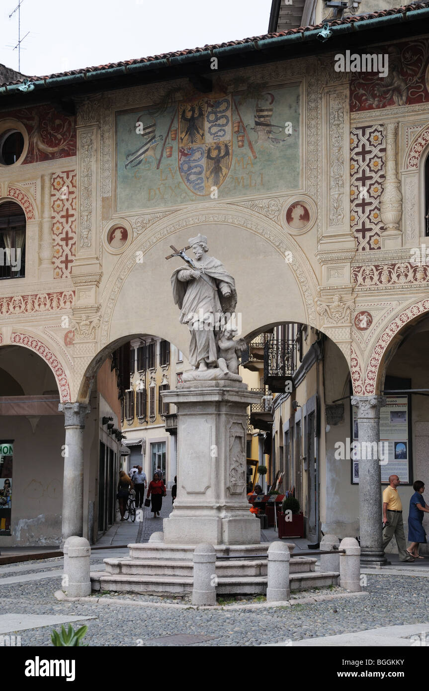Statue des Heiligen Kreuz mit Engel zu seinen Füßen Piazza Ducale Vigevano Italien mit Wappen der Visconti hält an Wand gemalt Stockfoto