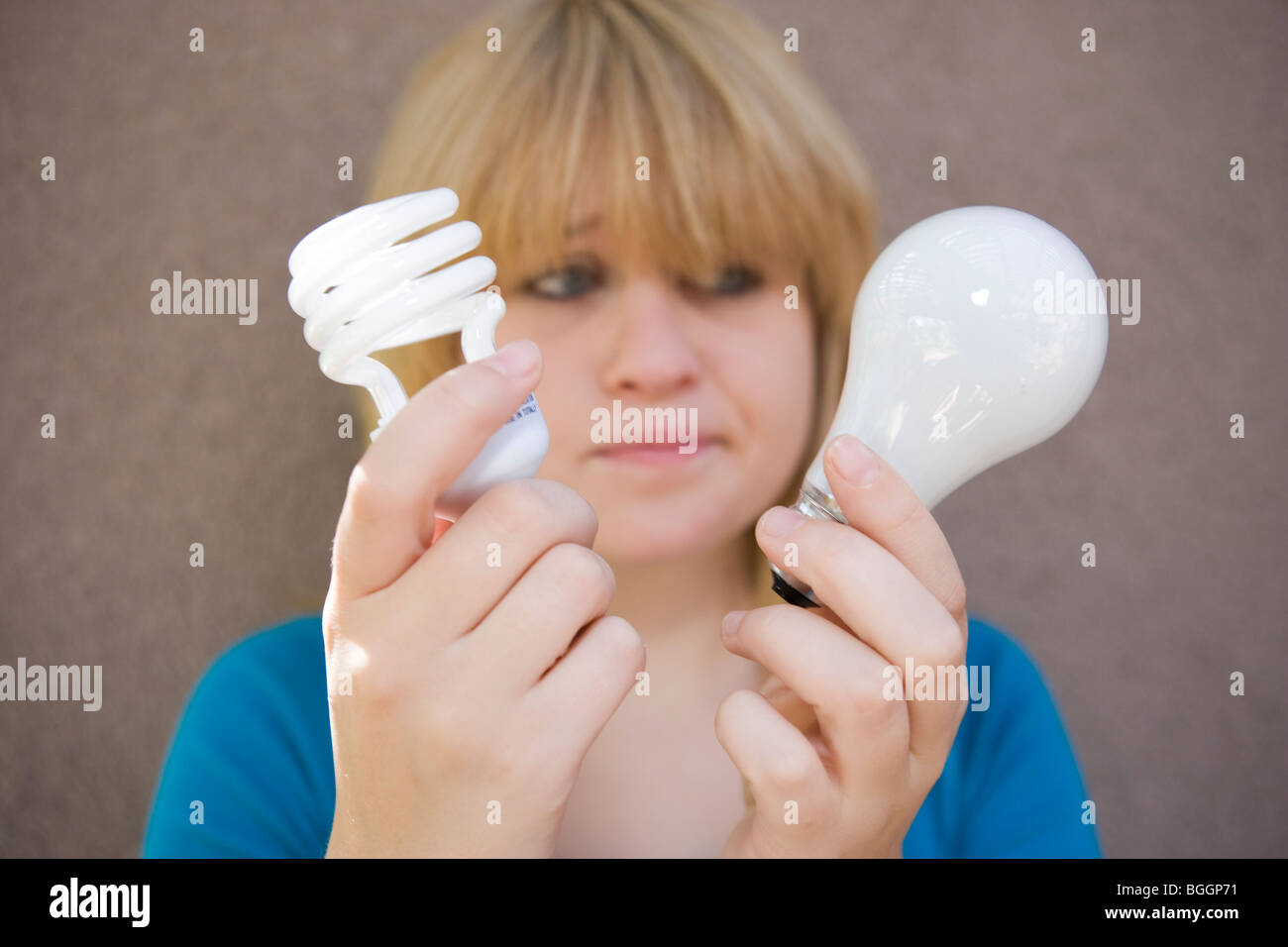 Teenager-Mädchen mit zwei Glühbirnen - traditionelle und Energie effiziente Stockfoto