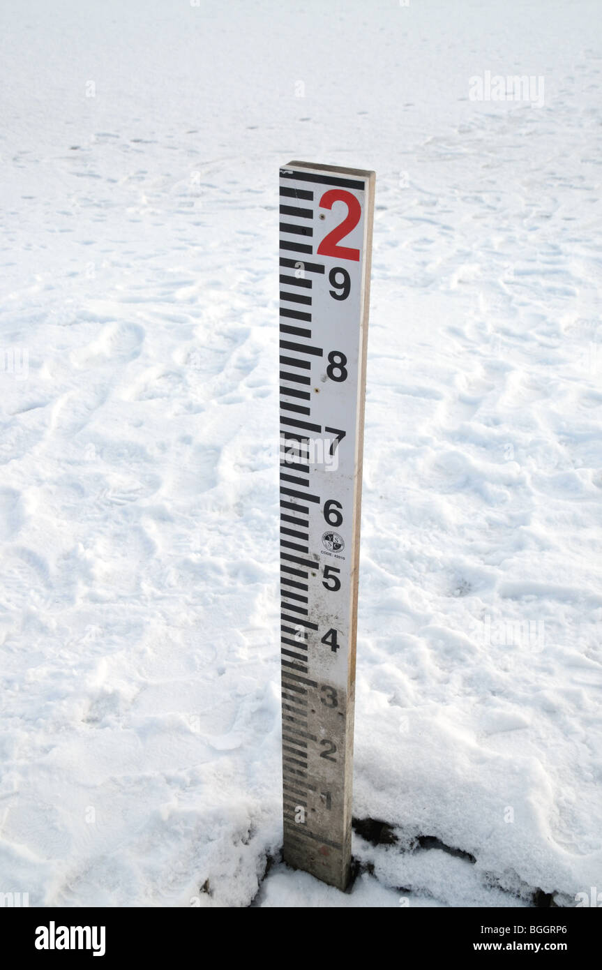 Einem zugefrorenen und verschneiten See mit Wasser Indikator messen. Stockfoto