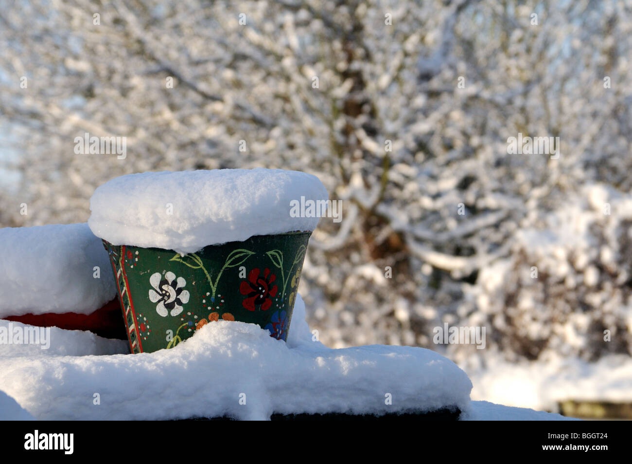 Winterschnee bedeckt den Blumentopf auf einem Narrowboat auf der Grand Union Canal, UK. Stockfoto