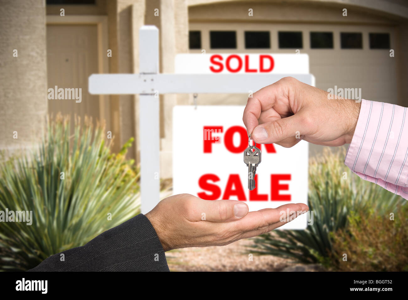 Ein Grundstücksmakler übergibt den Schlüssel an einem neuen Käufer von Eigenheimen nach der Verkauf endgültig ist. Stockfoto