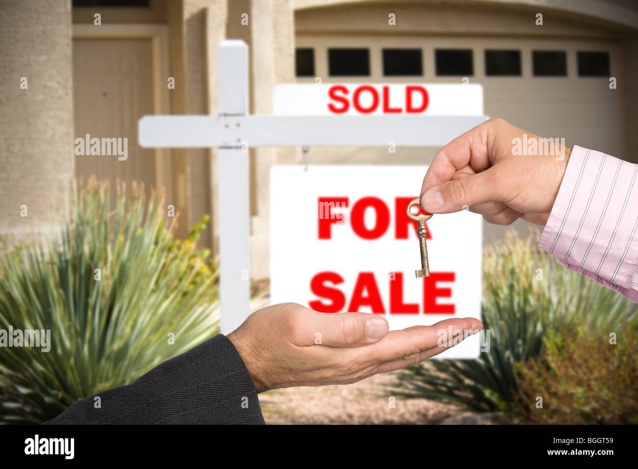 Ein Grundstücksmakler übergibt den Schlüssel an einem neuen Käufer von Eigenheimen nach Abschluss der Transaktion. Stockfoto
