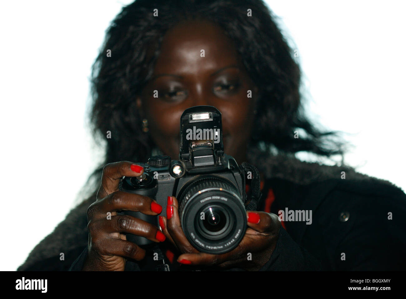 Eine junge afrikanische Frau prüft das Bild, das sie gerade auf ihrer Digitalkamera genommen hat Stockfoto