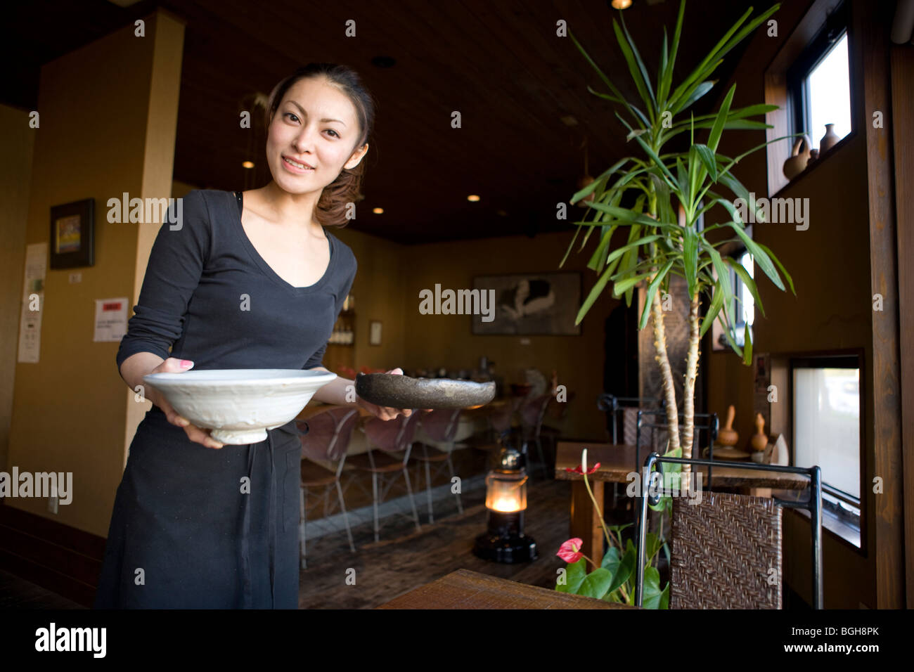 Junge Frau mit Speisen am Tisch Stockfoto