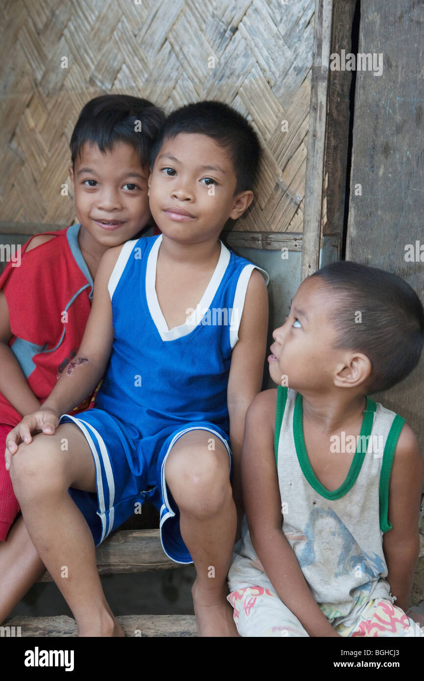 Drei philippinische jungen sitzen auf Stufe des Hauses; Coron Town; Busuanga Island; Philippinen. Stockfoto