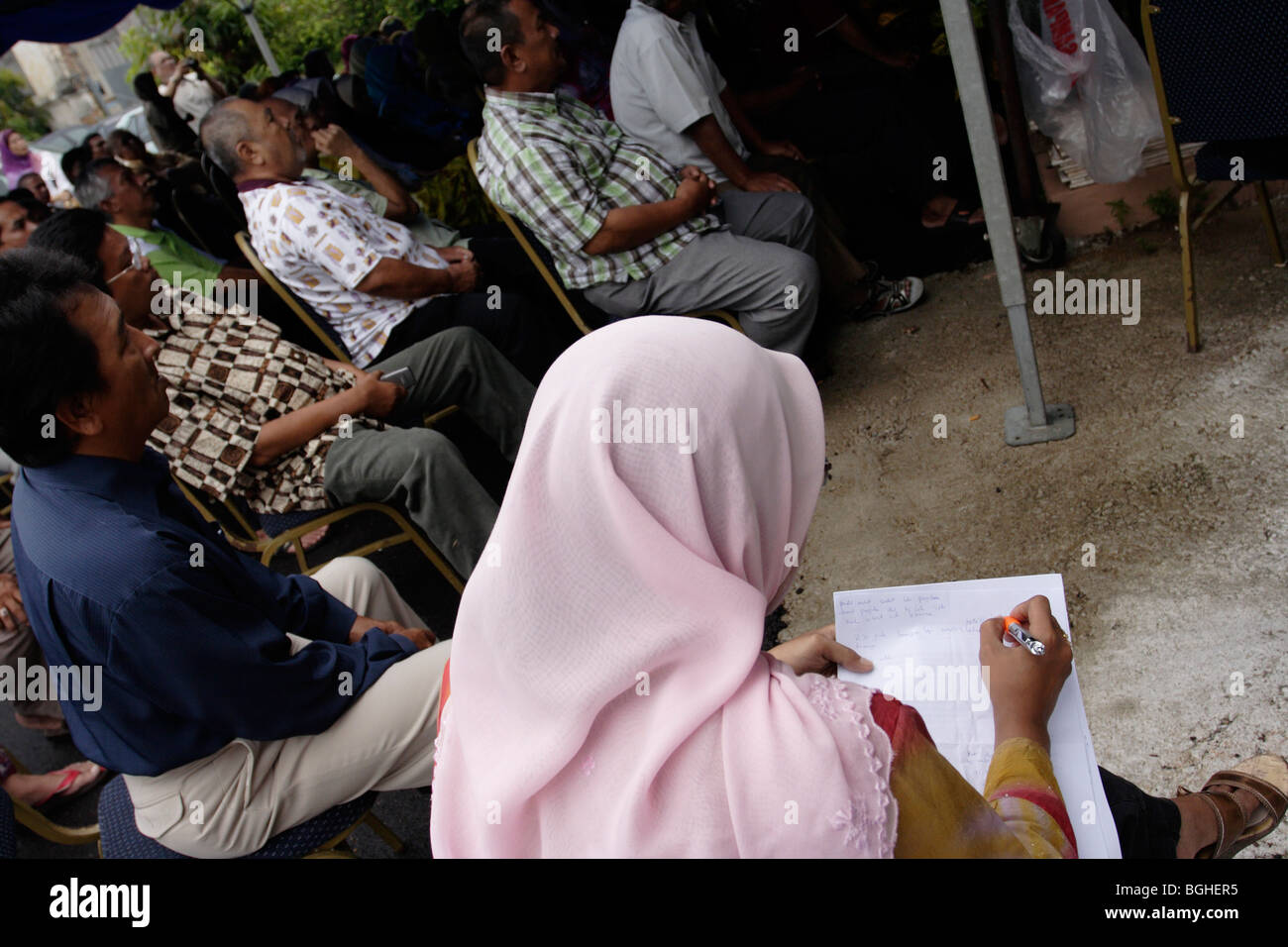 Eine muslimische Reporterin mit kurzer Hand um Notizen in Malaysia Stockfoto