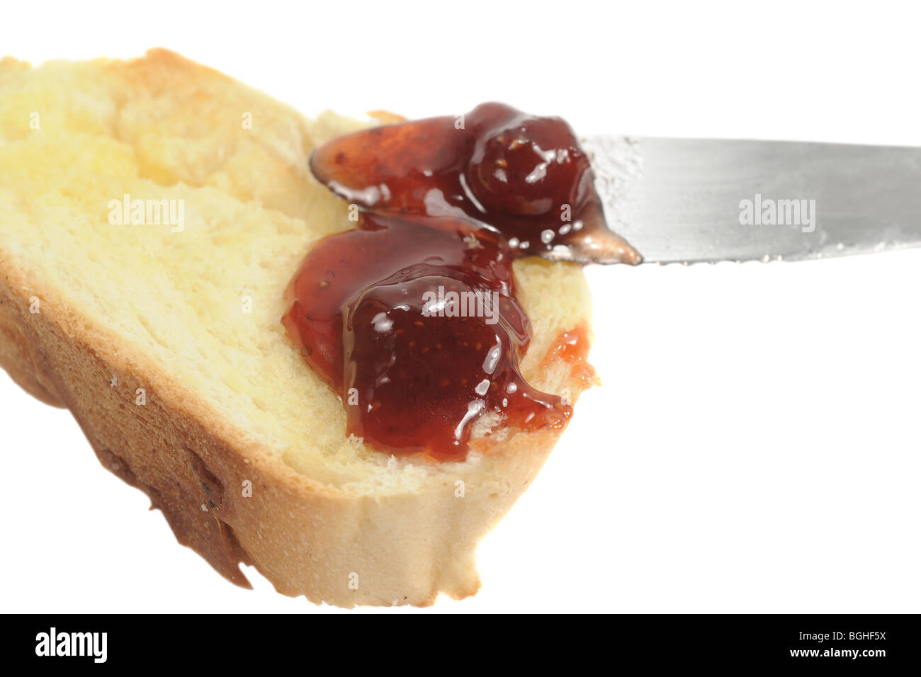 Messer, die Verbreitung von Gelee auf ein Stück Brot auf weiß Stockfoto
