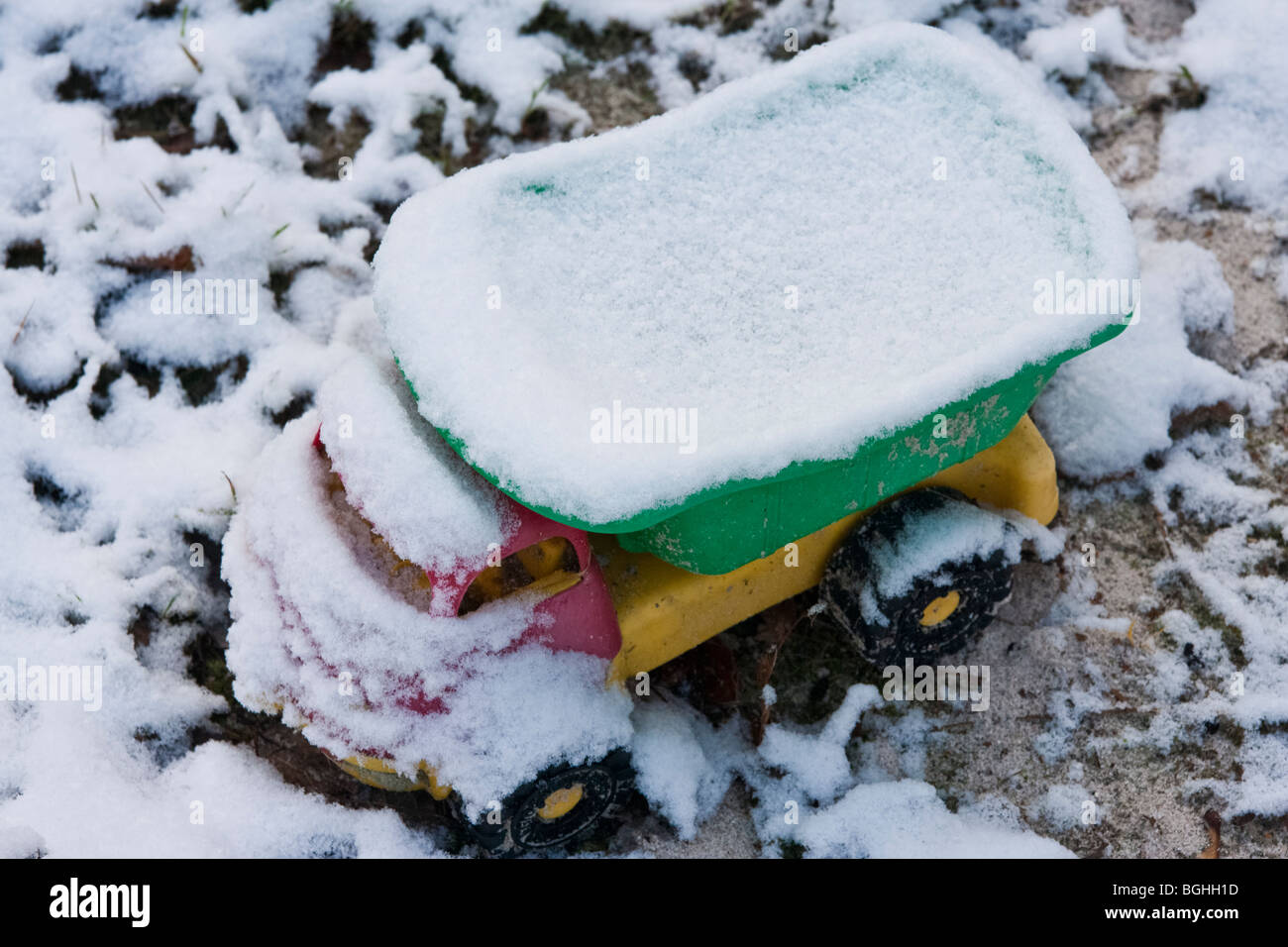 Kunststoff-Spielzeug LKW bedeckt mit Schnee im Garten Stockfoto