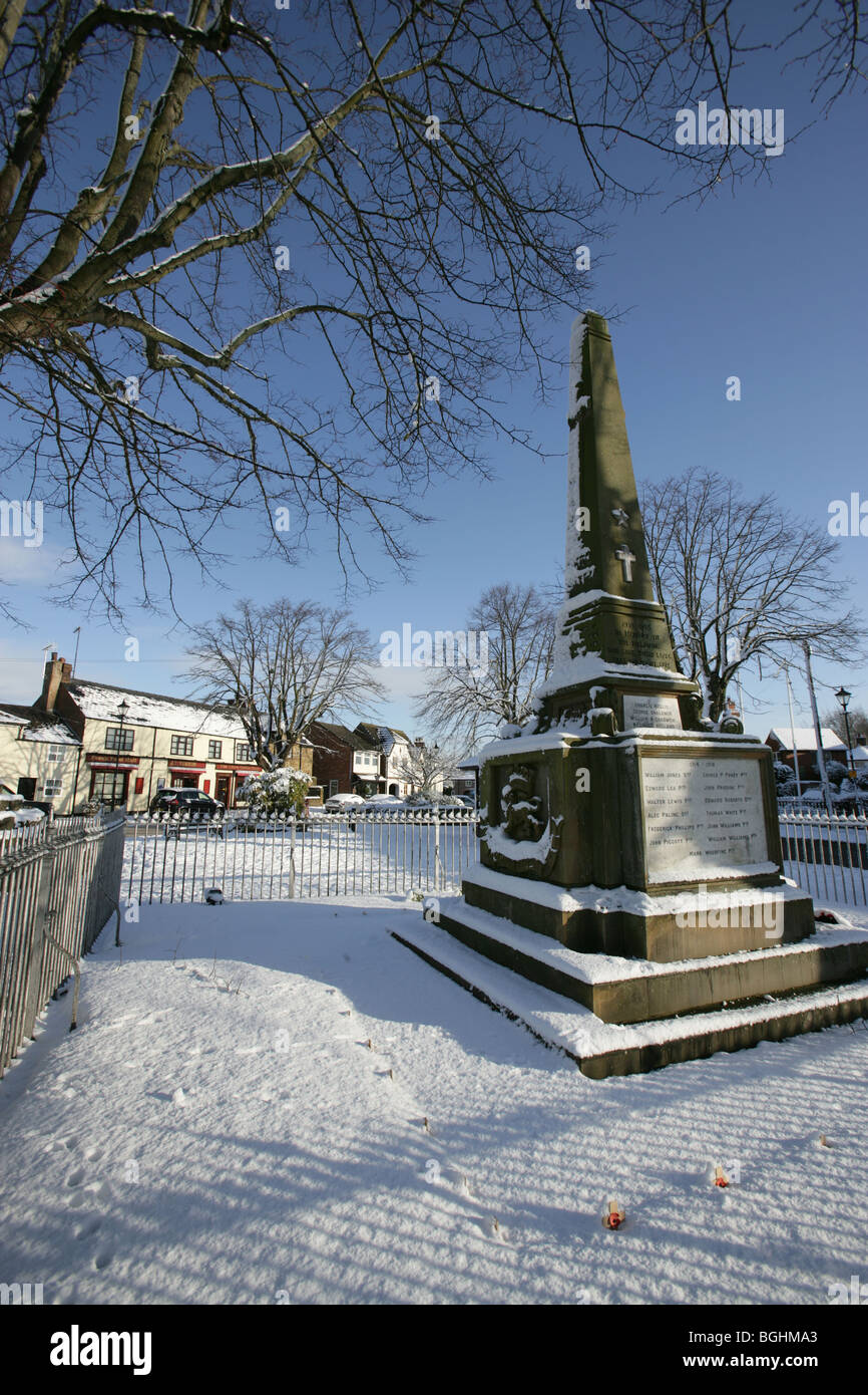 Dorf Holt, Wales. Malerische Aussicht auf den ersten und zweiten Weltkrieg Denkmal im Dorfzentrum Holt an einem kalten verschneiten Tag. Stockfoto