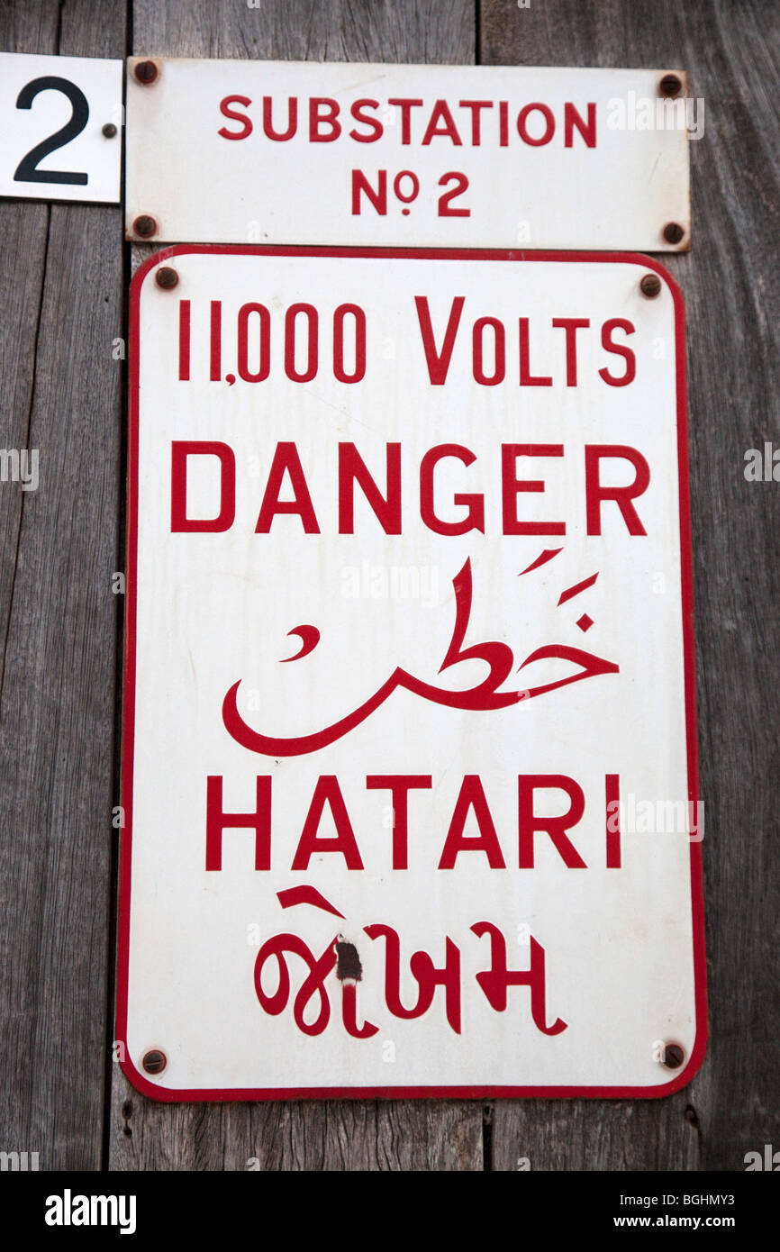 Stone Town, Sansibar, Tansania. Multi-linguale Schild (Englisch, Arabisch, Swahili, Hindi) an einem elektrischen Transformator. Stockfoto