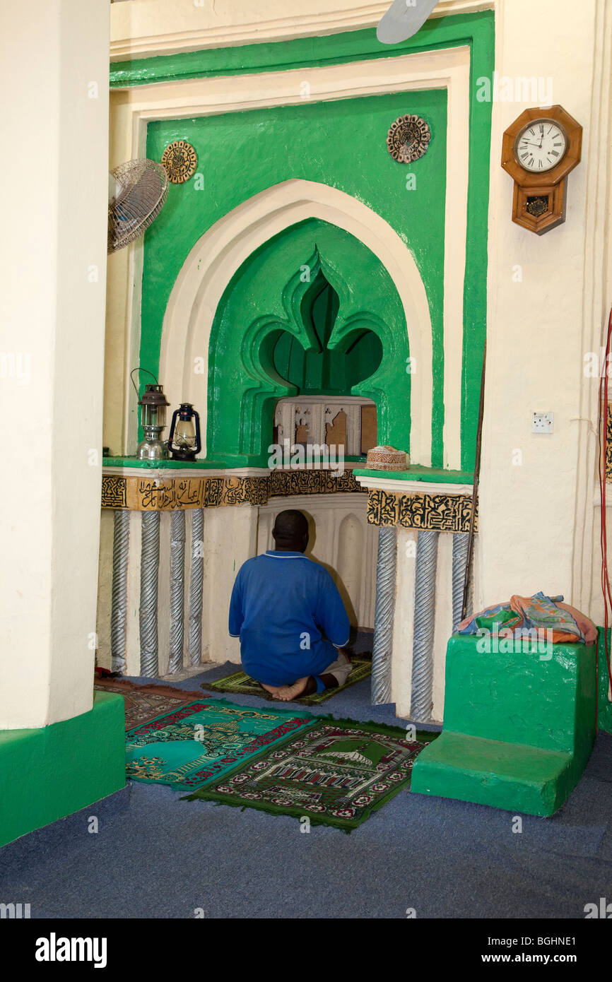 Kizimkazi, Sansibar, Tansania. Imam Beten in Mihrab der Moschee, mit Beschriftung bis 1107 datierte A.D. Stockfoto