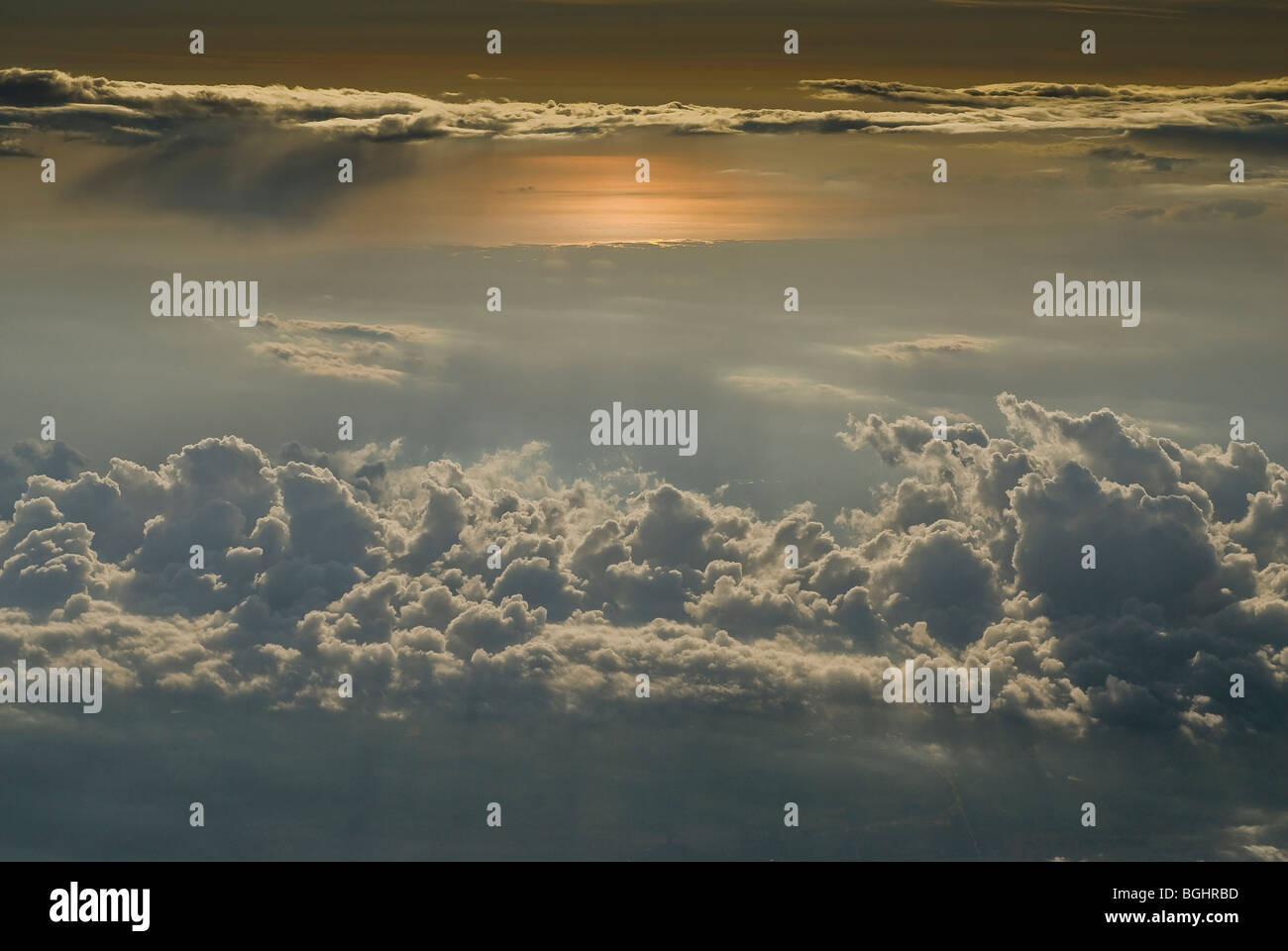 glühende Sonne am Horizont flauschigen Wolken Vordergrund Stockfoto