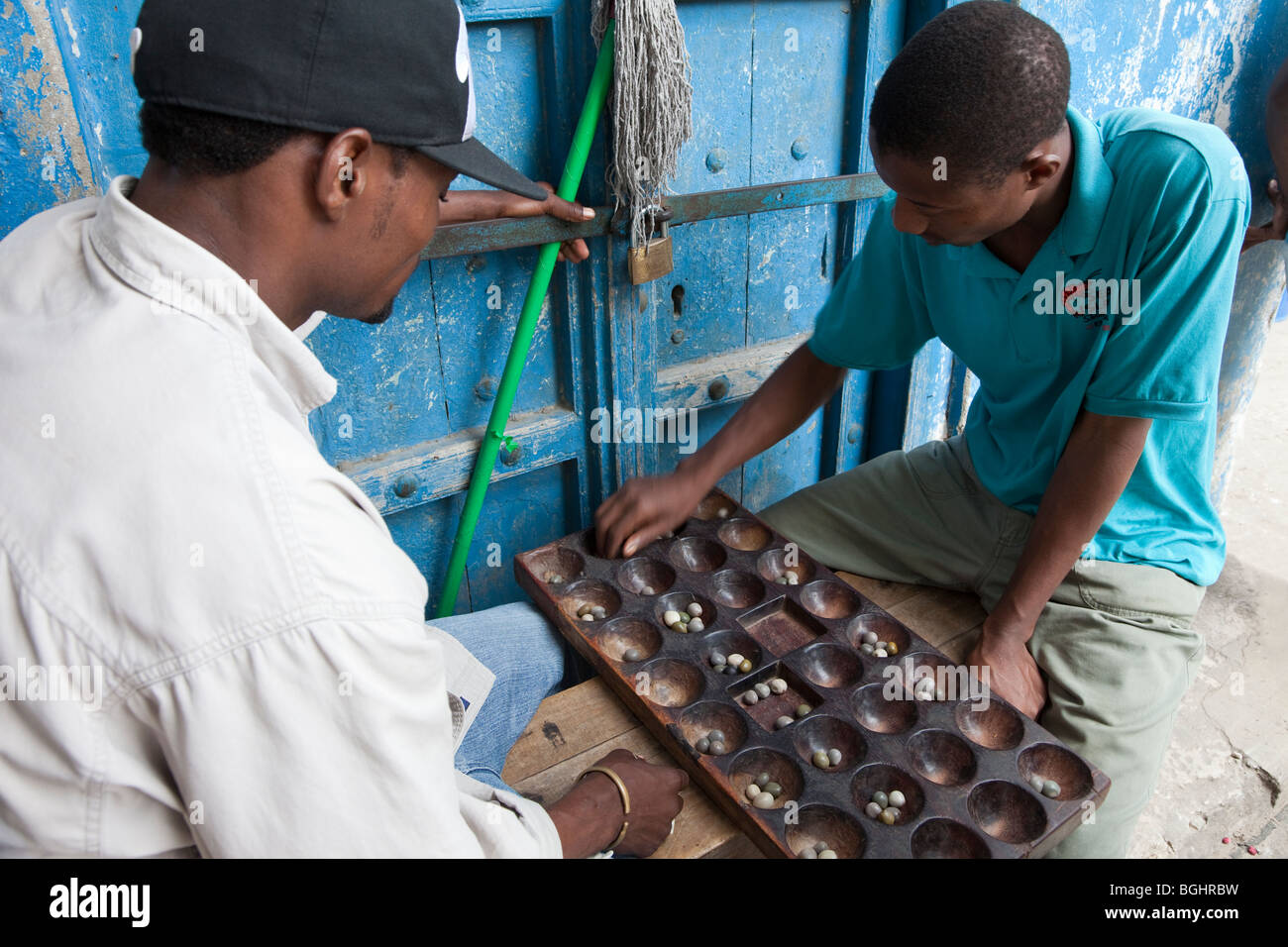 Sansibar, Tansania. Männer spielen Bao, einem traditionellen afrikanischen Spiel. Stockfoto