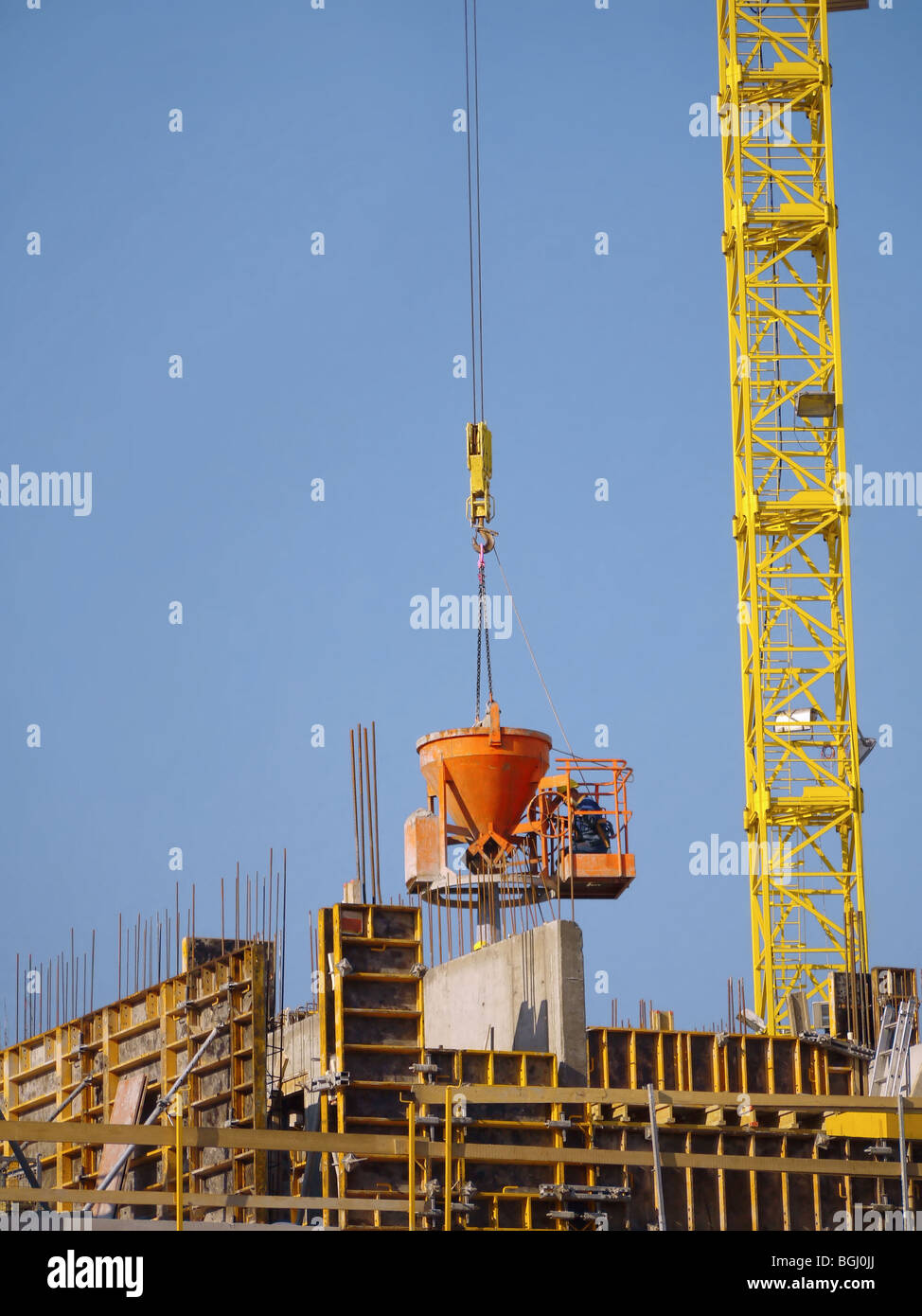 Bau Arbeiter Gießen von Beton mischen von Aufgabetrichter mit Jib Kran transportiert Stockfoto