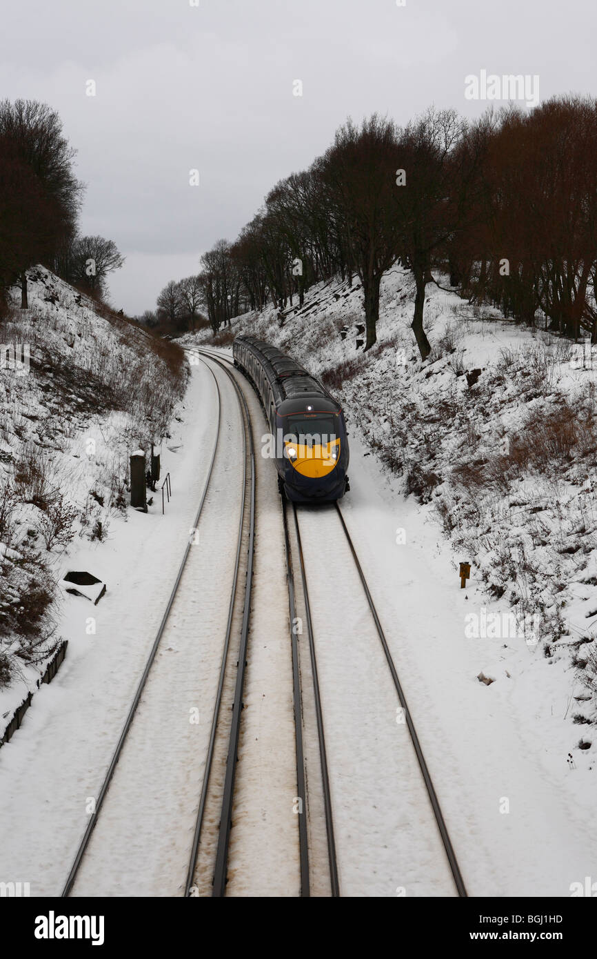 Ein Hitachi Javelin Hochgeschwindigkeitszug Rauschen durch die verschneite Winterlandschaft von Kent in England Stockfoto