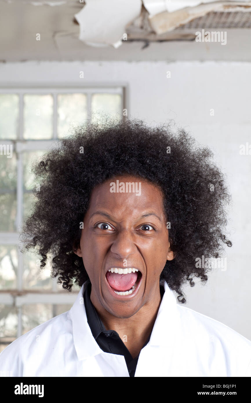 Ein junger schwarzer Mann mit einem Afro machen verschiedene Gesichtsausdrücke während des Tragens eines Laborkittel Stockfoto