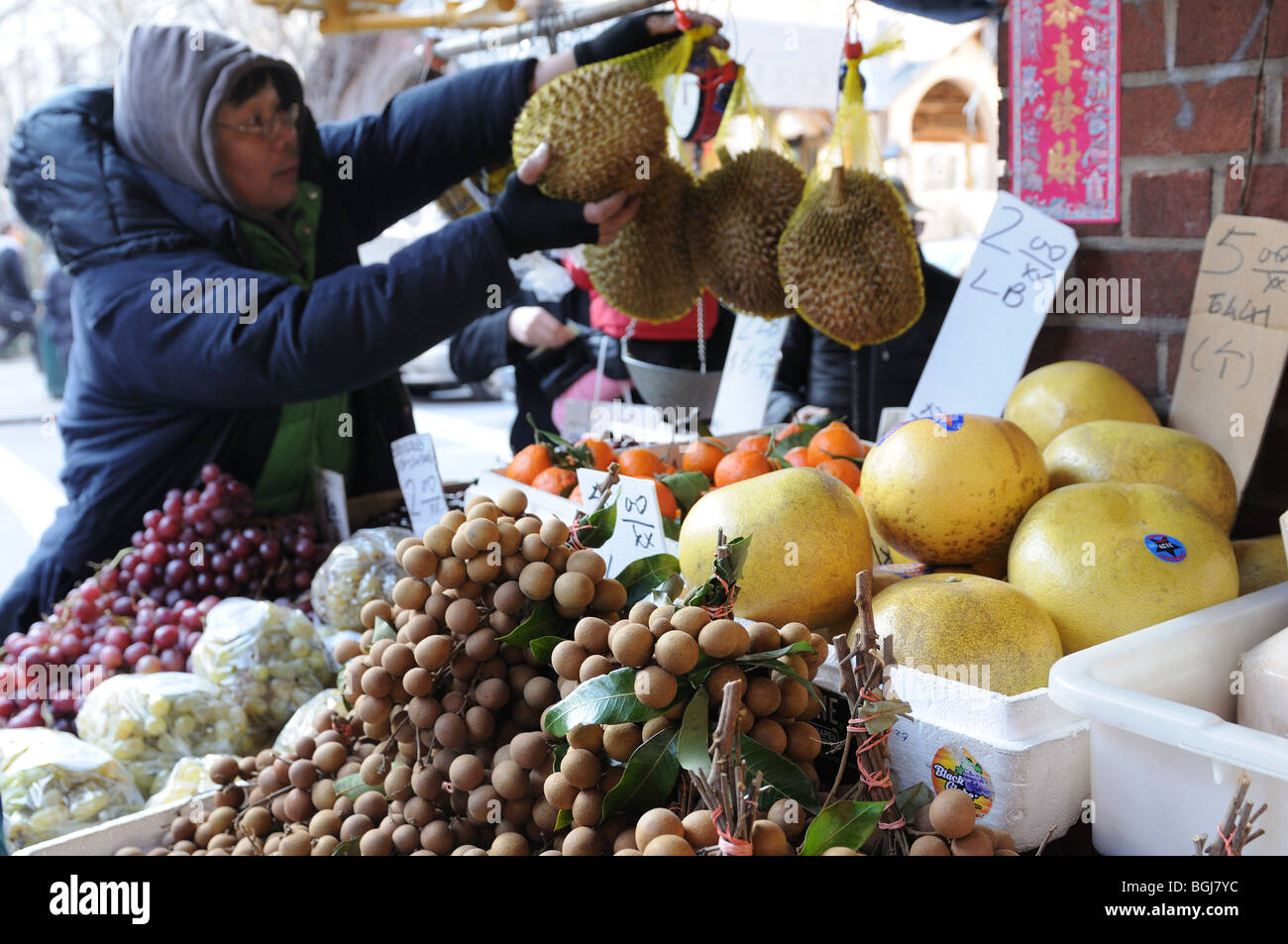 Eine Produkt-Anbieter in Manhattans Chinatown verkauft Litschi Muttern und Durian zusammen mit anderen Früchten. Stockfoto