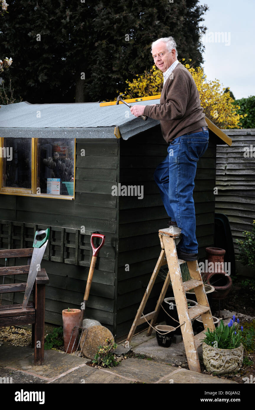 Ein pensionierter Mann wieder Filzen ein Pultdach UK Stockfoto