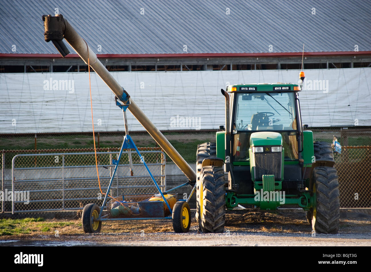 Traktor und Gülle Rohr am Milchviehbetrieb Güllegrube Stockfoto
