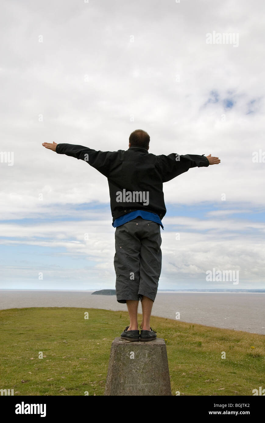 Mann steht auf einem Sockel, ausgestreckten Armen, Blick auf das Meer, Brean Down, Somerset, England, Großbritannien, Europa Stockfoto