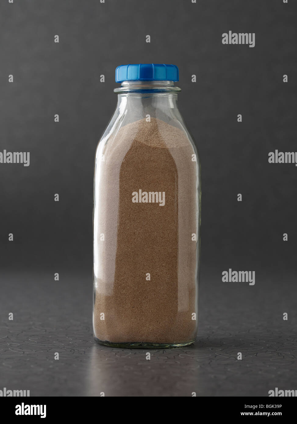 Schokolade Milch-Protein-Pulver in Milchflasche auf graue Oberfläche Stockfoto