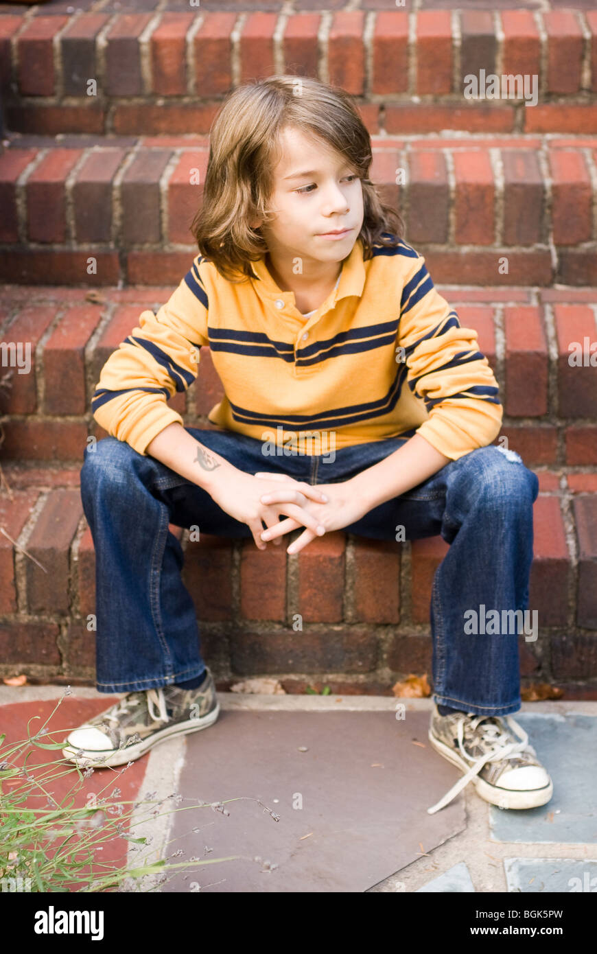 Junge sitzt auf Treppe Stockfoto