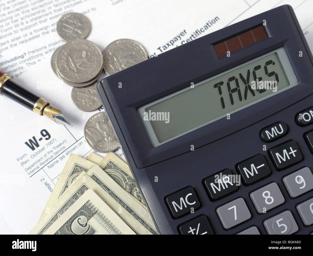 Taschenrechner mit lcd Anzeige steuern Wort mit Stift und US-Dollar auf w-9 Einkommensteuer Formen gelegt. Stockfoto