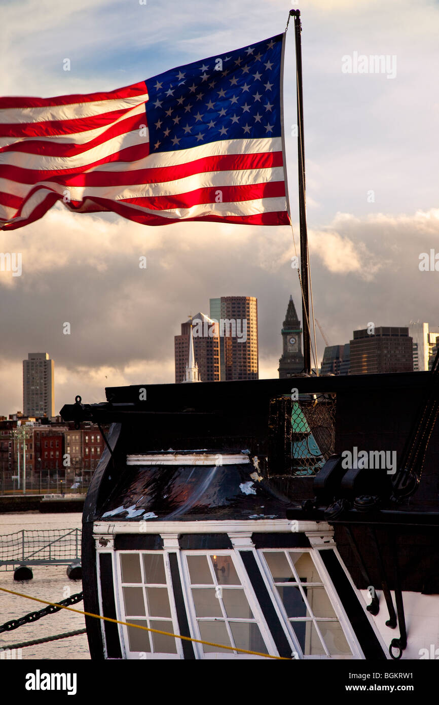 Amerikanische Flagge, die vom Heck der USS Constitution mit den Gebäuden der Innenstadt von Boston über, Massachusetts, USA Stockfoto